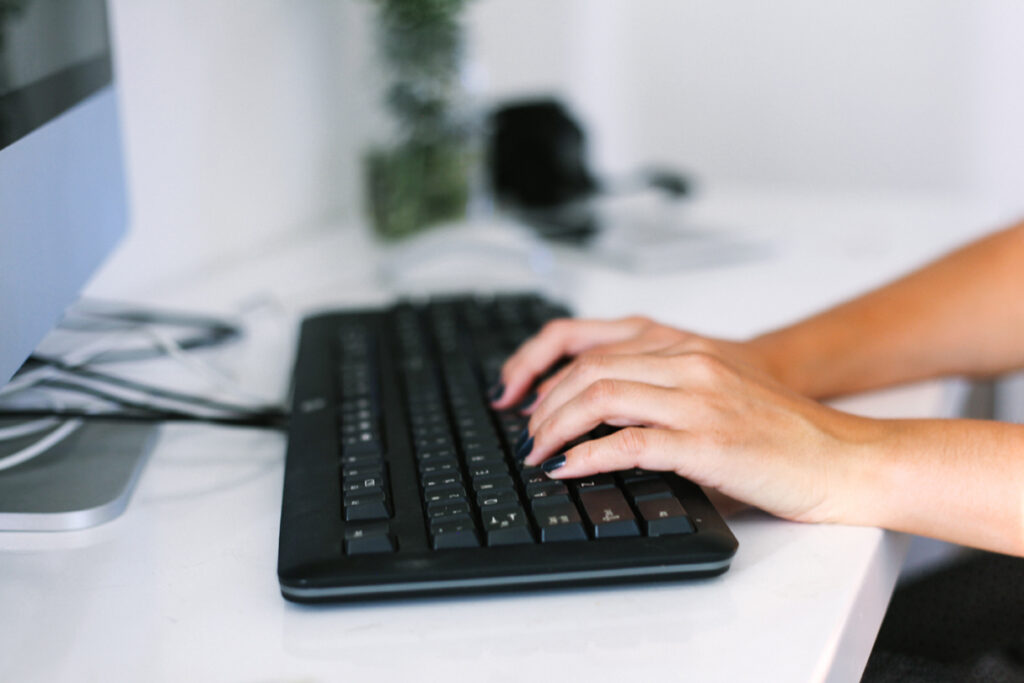 A person typing on a black keyboard