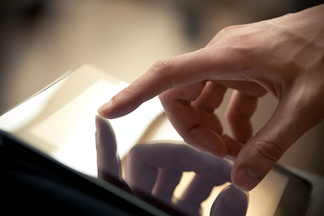 Man hand touching screen on modern digital tablet pc. Close-up image with shallow depth of field focus on finger.
